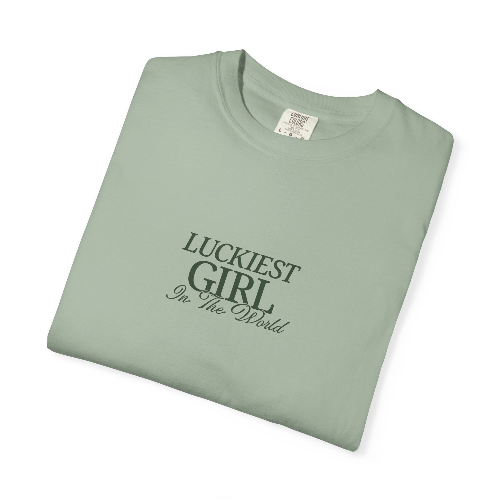 Folded green t-shirt with 'Luckiest Girl in the World' text on a white background
