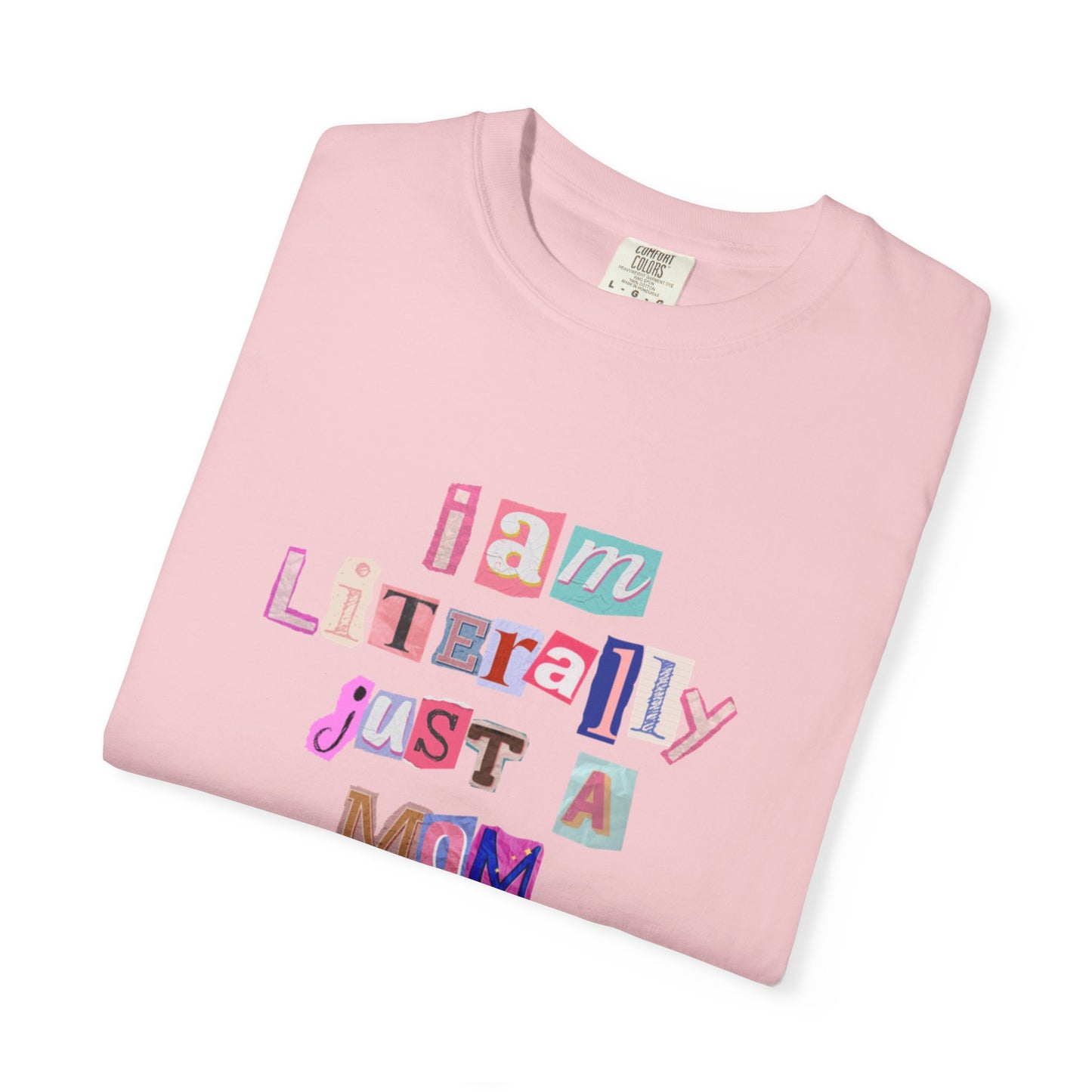 Folded pink t-shirt with colorful text "I am Literally Just a Mom" on a white background