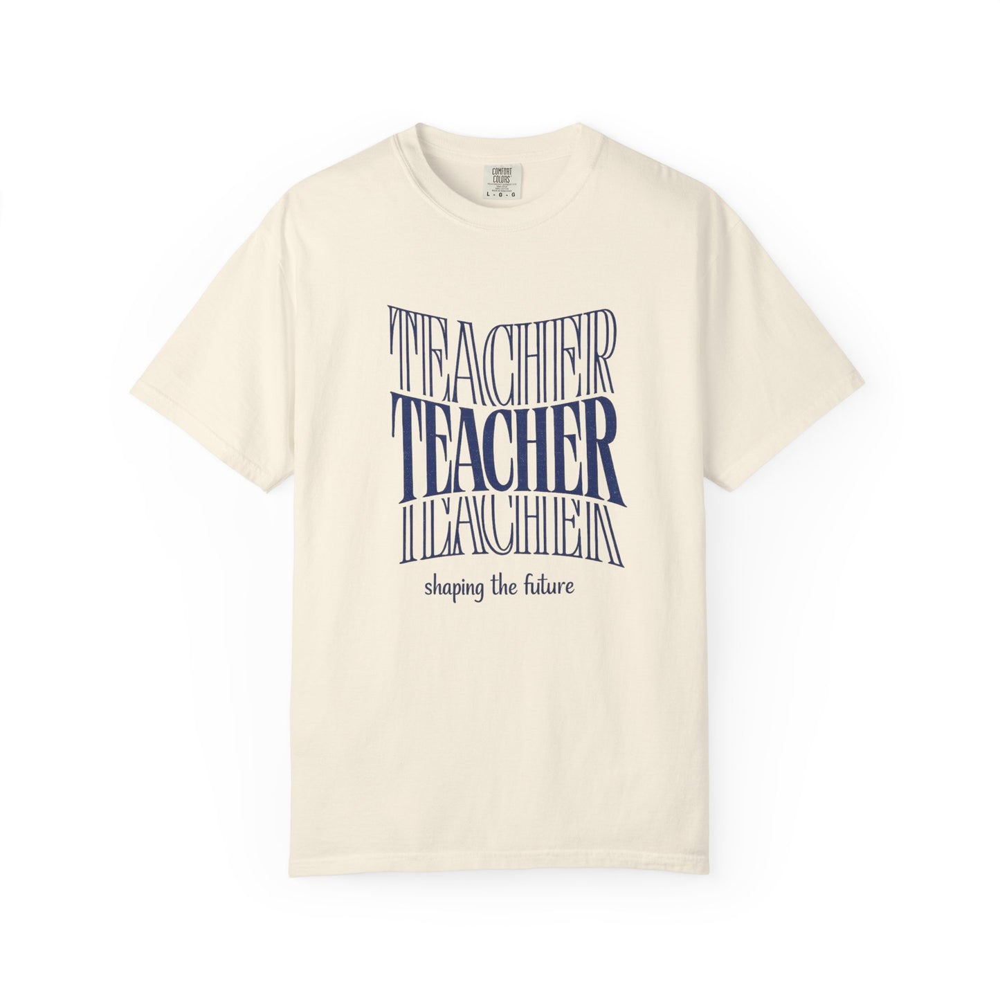 Beige t-shirt with blue text "Teacher shaping the future" on a white background