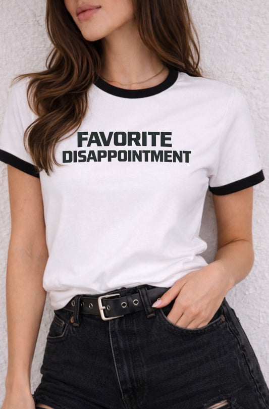Person wearing a white t-shirt with 'FAVORITE DISAPPOINTMENT' text against a light background