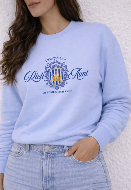 Light blue sweatshirt with 'Rich & Aunt' logo worn by a person on a white background