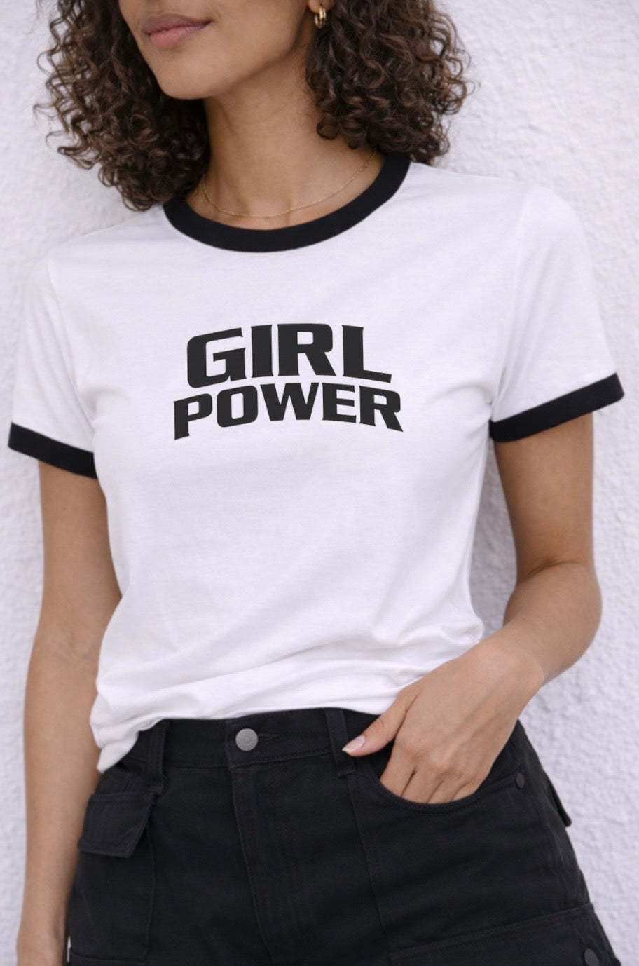 Person wearing a white t-shirt with 'GIRL POWER' text against a light background