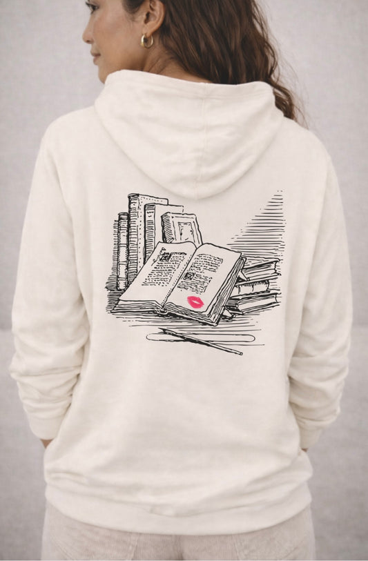 Person wearing a white hoodie with a book graphic design on the back against a gray background