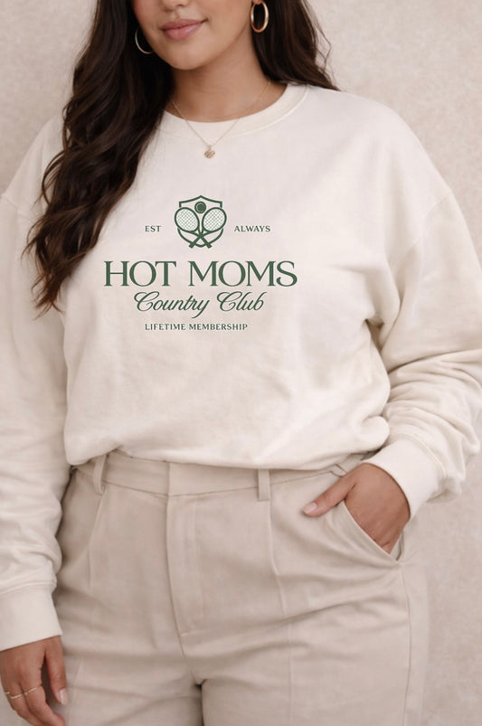 Person wearing a white sweatshirt with 'Hot Moms Country Club' text and design.